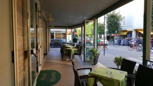 a restaurant with tables and chairs on a street at Hotel Marietta in Caorle