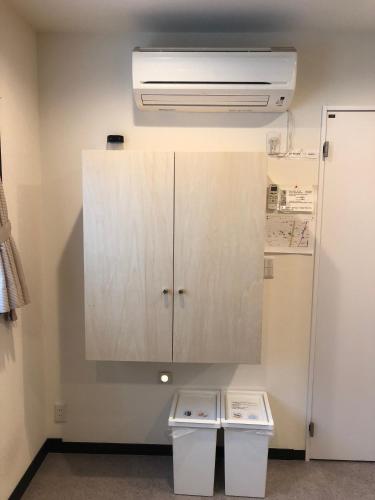 a kitchen with a cupboard and two trash cans at Tokyo Art House in Tokyo