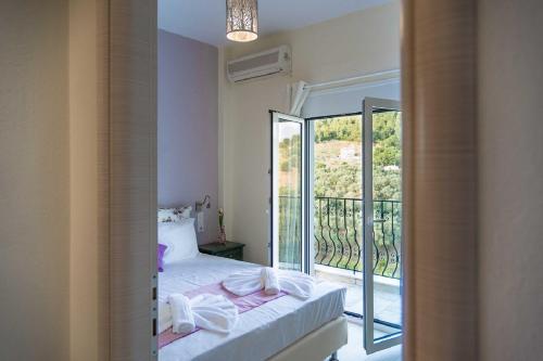 a bedroom with a bed and a large window at Villa Albanis in Kolios