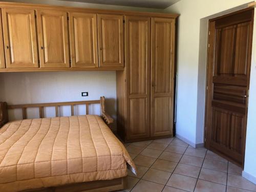 - une chambre avec un lit et des placards en bois dans l'établissement Monolocale Belvedere vda La Thuile CIR 0067, à La Thuile