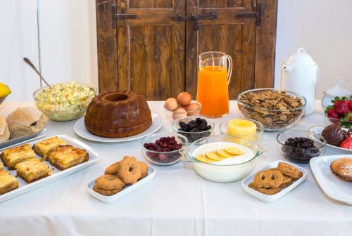 un tavolo apparecchiato con diversi tipi di cibi per la colazione di Villa Lucrezio Resort a Cutrofiano