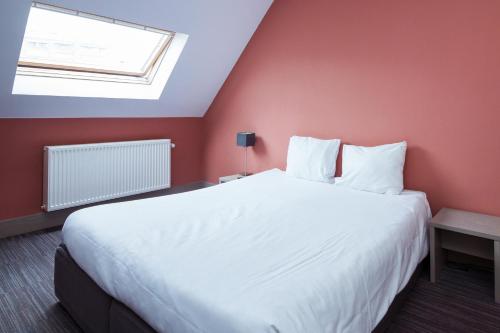 a bedroom with a large white bed and a window at Enjoy Hotel Blankenberge - Pantheon Palace By WP Hotels in Blankenberge