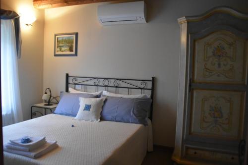 a bedroom with a bed with blue pillows at Affittacamere Valnascosta in Faedis