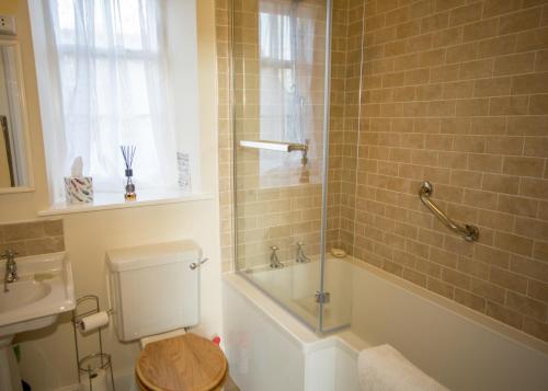 a bathroom with a toilet and a tub and a sink at Errington House in Hexham
