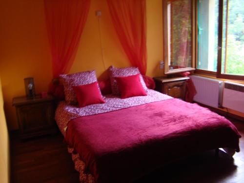 - une chambre avec un lit avec des draps roses et une fenêtre dans l'établissement Mas Nogarede, à Corsavy