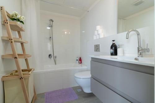 een witte badkamer met een toilet en een wastafel bij Enjoy Views of Jerusalem from Chic Flat in Jeruzalem