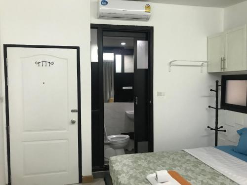 a bedroom with a bed and a bathroom with a toilet at Nine Place Sukhumvit 40 in Bangkok