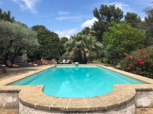 una piscina en un jardín con árboles en Du Coté de Chez Soi en La Ciotat