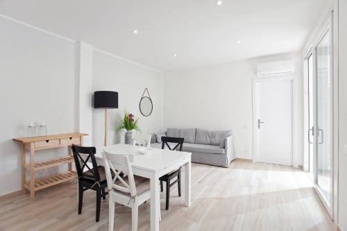 a white dining room with a white table and chairs at La Casa di Mattia in Pula