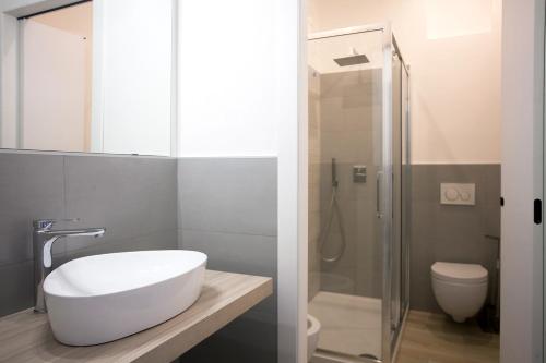 a bathroom with a white sink and a shower at La Casa di Mattia in Pula