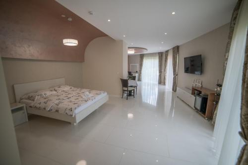 a bedroom with a bed and a desk and a television at Hotel Urban in Bužim