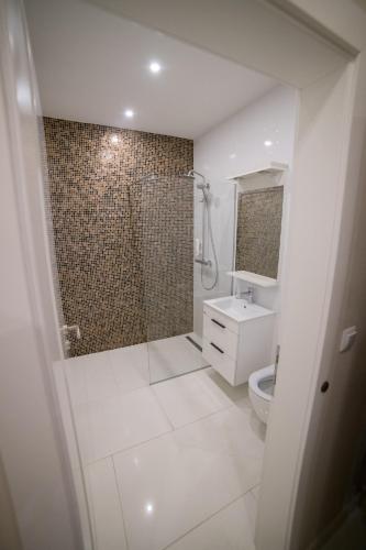 a bathroom with a shower and a sink and a toilet at Hotel Urban in Bužim
