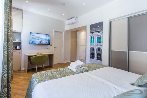 a hotel room with a large bed and a desk at AML apartments in Split