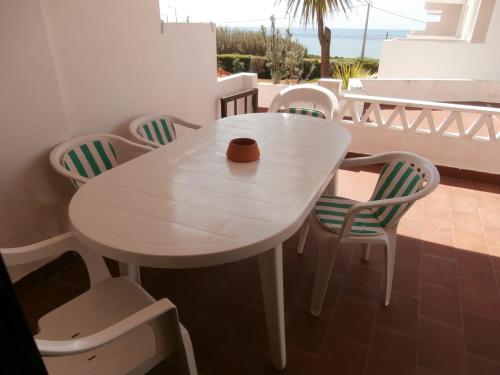 a white table and chairs on a balcony at Mar a Vista Family Apartment in Ericeira