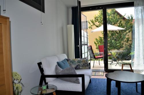 a living room with a white couch and a patio at Hochlandappartement in Dresden