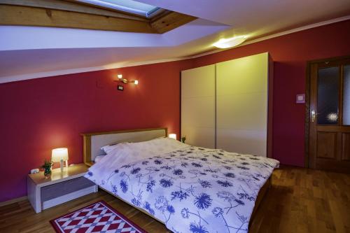 a bedroom with a bed and a red wall at Apartment Anai Rijeka in Rijeka