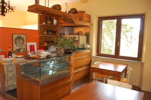 a kitchen with a counter and a table and a window at Mariani Bed&Breakfast in Castellina in Chianti