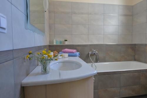 a bathroom with a sink and a bath tub at Lidromi Home (Blue) in Alonnisos Old Town