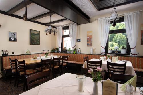 ein Restaurant mit Tischen und Stühlen in einem Zimmer in der Unterkunft Zum Waldhorn in Peterstal