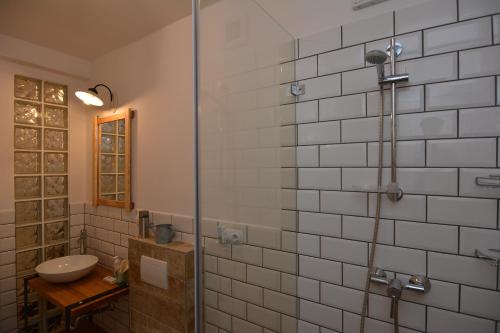 エゲルにあるMini Loft Apartmanのバスルーム(洗面台、ガラス張りのシャワー付)