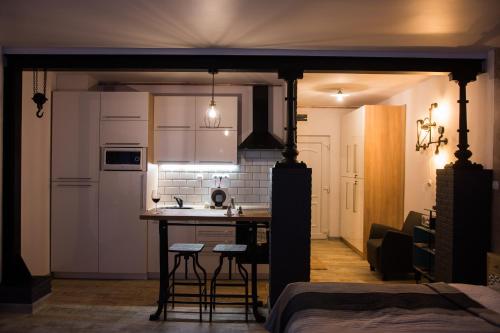 eine Küche mit einem Tisch und Stühlen im Zimmer in der Unterkunft Mini Loft Apartman in Eger