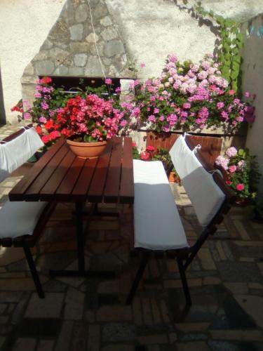 a wooden table and chairs and flowers on a patio at Apartment Castel in Bale