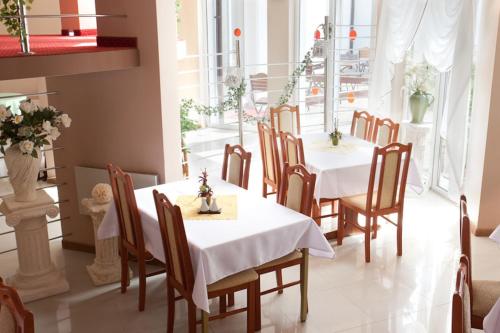 a dining room with two tables and chairs with flowers at Willa Rawia 2 in Rewal