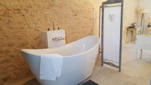 een badkamer met een wit bad in een kamer bij La Manilau in Le Buisson de Cadouin