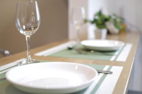 a table with a white plate and a wine glass at Guesthouse Tokushima in Tokushima