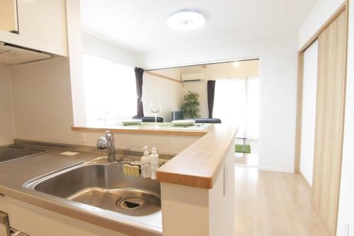 a kitchen with a sink and a counter top at Guesthouse Tokushima in Tokushima