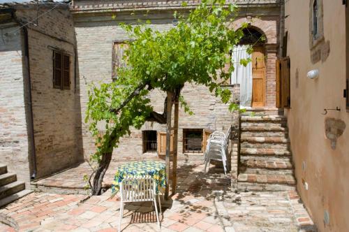 a table and chairs in front of a building at B&B La Cappellania in Montegiorgio