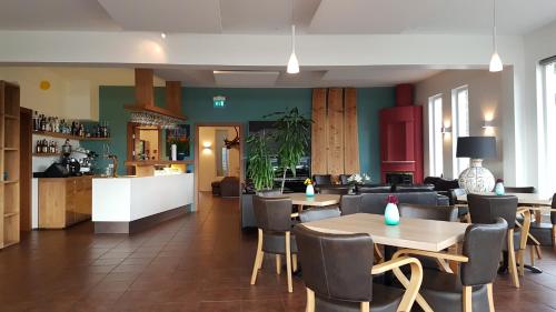 a restaurant with tables and chairs and a kitchen at Hotel Hallormsstadur in Hallormsstaður