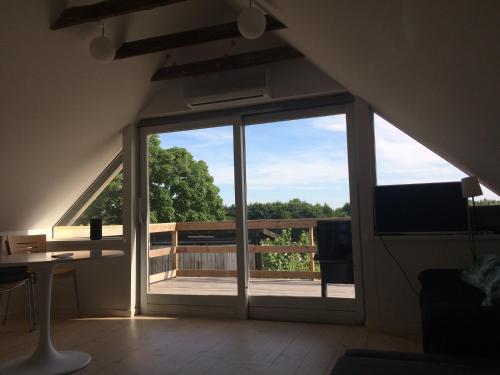 a room with a large sliding glass door with a balcony at Lejlighed på landet, NO Smoking in Kvistgård