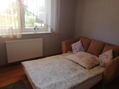 ein Sofa im Wohnzimmer mit Fenster in der Unterkunft Kwatery Prywatne Regina Pociask in Dziwnówek