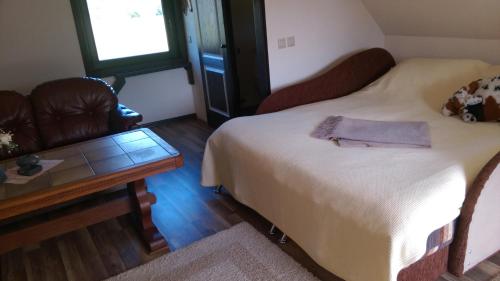 a room with a bed and a table and a couch at Aglonas Līdakas in Priežmale