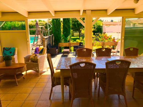 uma sala de jantar com uma mesa e cadeiras num pátio em Villa Felin Feline em LʼIsle-sur-la-Sorgue