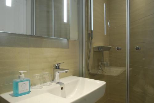 a bathroom with a sink and a shower with a mirror at Hotel am Südwäldchen in Westerland (Sylt)
