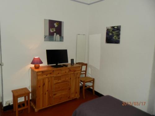 - une chambre avec une télévision sur une commode en bois dans l'établissement Les Lavandes, à Gréoux-les-Bains