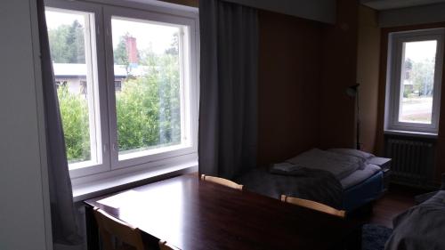 a bedroom with two windows and a desk and a bed at Imatran Portti in Imatra