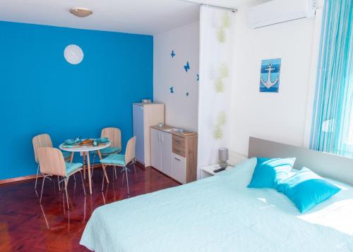 - une chambre avec un lit et une table avec des chaises dans l'établissement Studio apartman Tirkiz, à Zagreb
