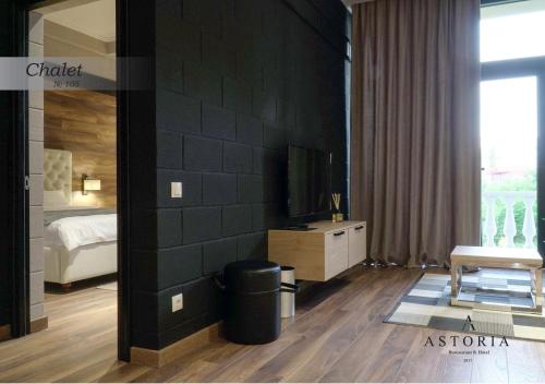 a bedroom with a bed and a tv on a wall at ASTORIA Boutique Hotel in Bălţi