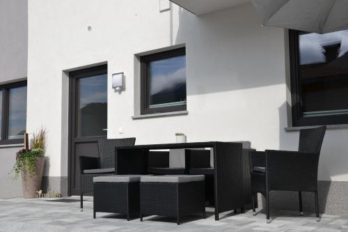 a patio with chairs and a table in front of a building at Apart Bergluft in Gerlosberg