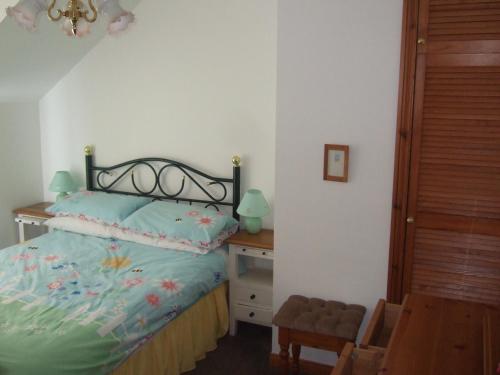 a bedroom with a bed and a table and a chair at Aird Cottage in Aird