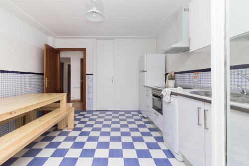 a kitchen with white cabinets and a blue and white checkered floor at La casa azul,una casa en la ciudad. in Logroño