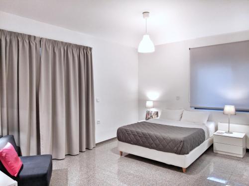 Habitación de hotel con cama y silla en Brand new budget apartment next to Iaso and Oaka, en Atenas