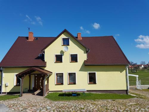 Piłaki Wielkie的住宿－MAZURY DWOREK PIŁACKI Dom，红色屋顶的大型黄色房屋