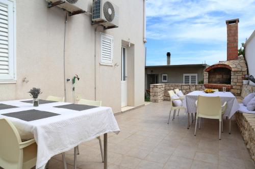 a patio with a white table and chairs on a patio at Villa Korculaholidays in Zavalatica