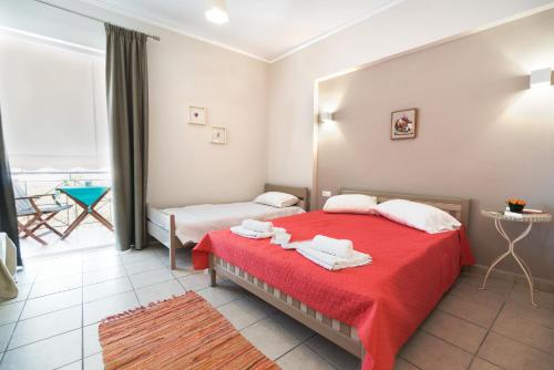 a bedroom with a red bed with towels on it at Angelika in Agios Andreas