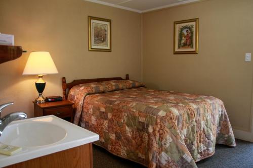 a hotel room with a bed and a sink at Kennebunk Gallery Motel and Cottages in Kennebunk