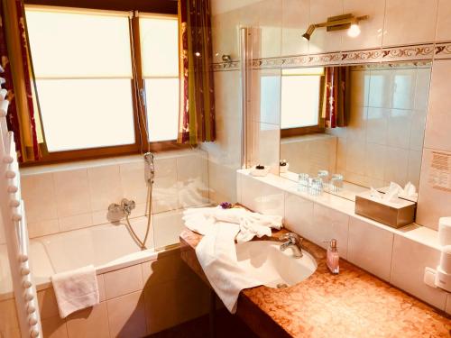 a bathroom with a sink and a shower and a mirror at Hotel am See - Seeresidenz in Altaussee
